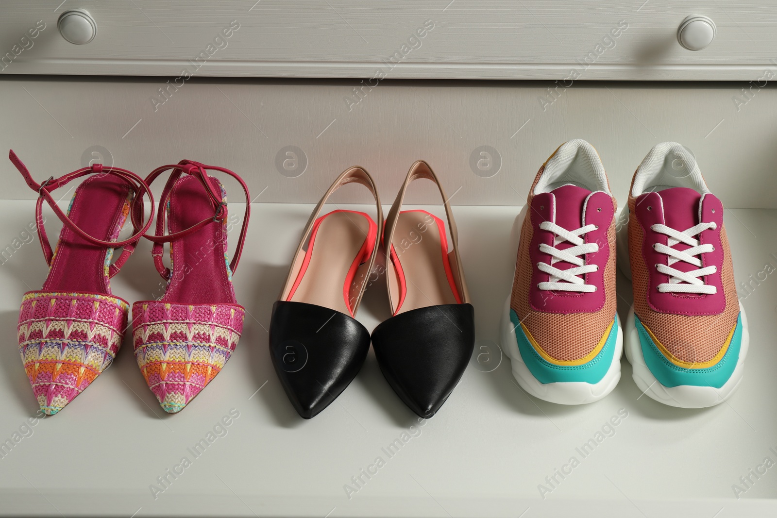 Photo of Different women's shoes in open drawer. Footwear storage