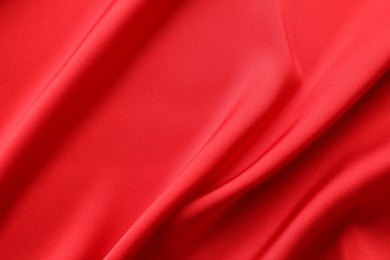 Crumpled red silk fabric as background, top view