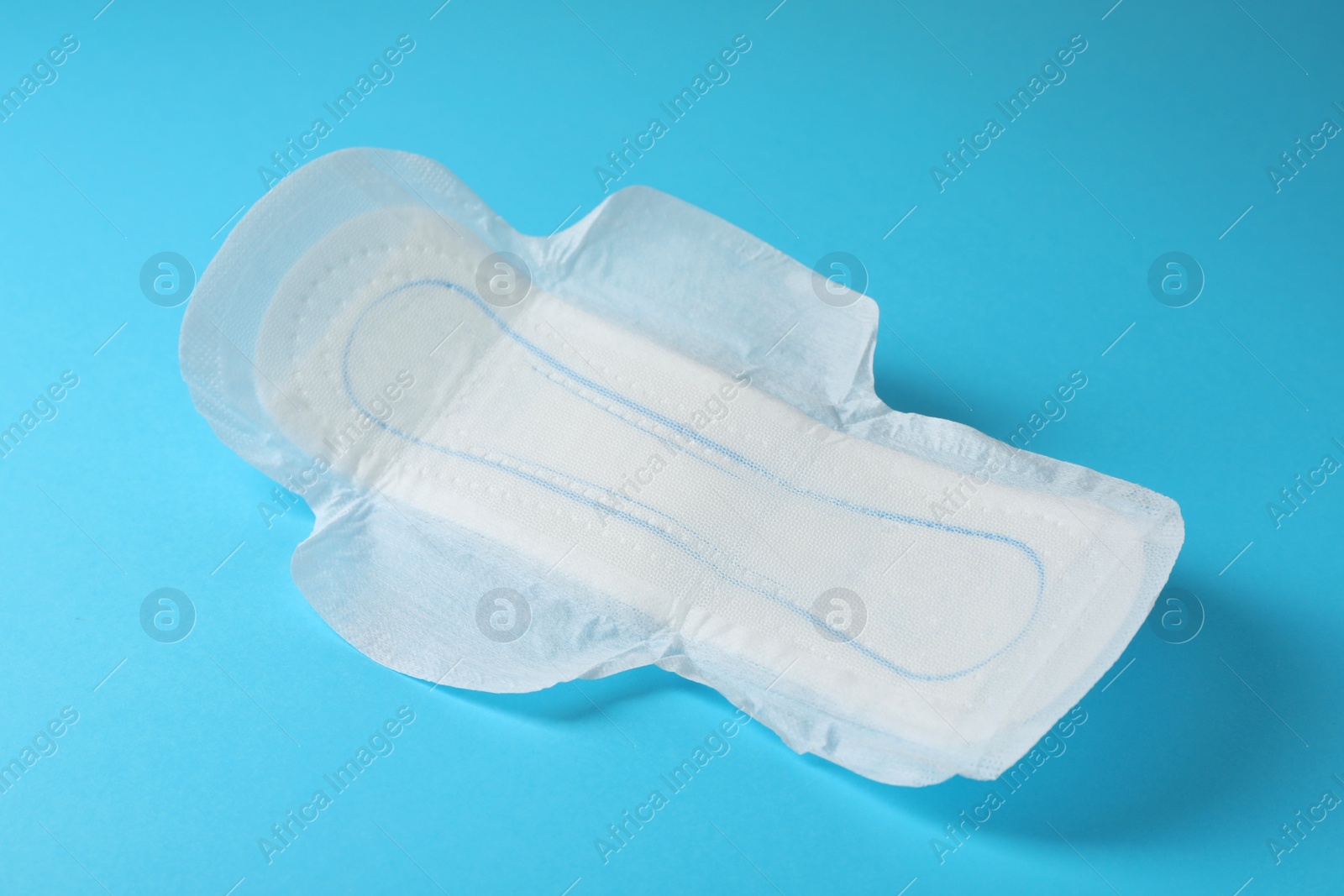 Photo of Sanitary napkin on light blue background. Gynecology concept