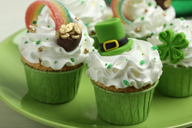 St. Patrick's day party. Tasty festively decorated cupcakes on table, closeup