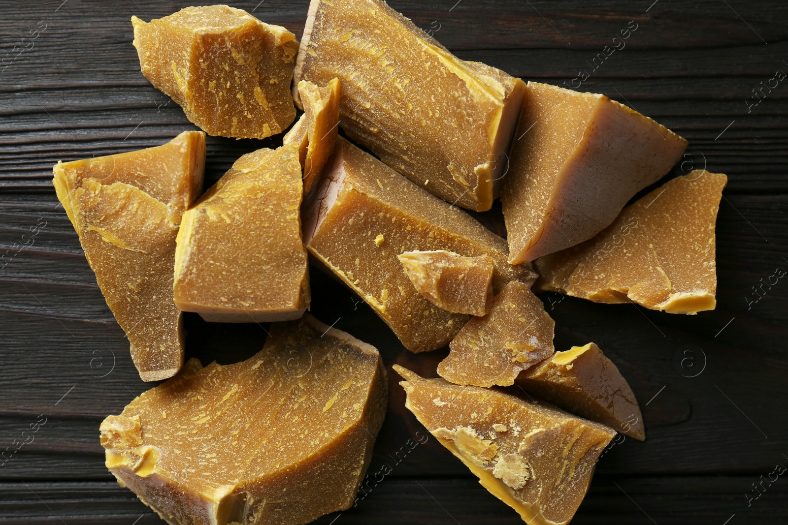 Photo of Natural organic beeswax blocks on wooden table, flat lay