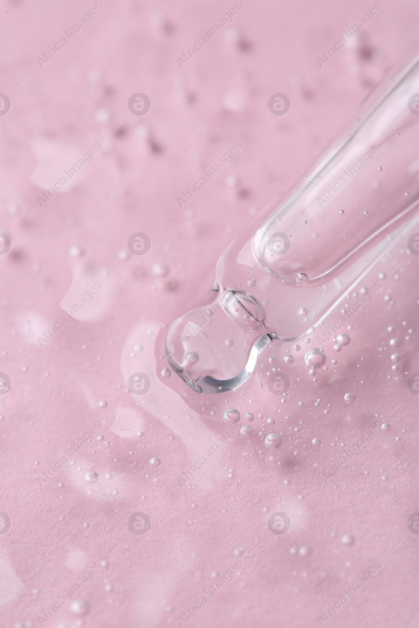 Photo of Pipette with cosmetic serum on pink background, closeup