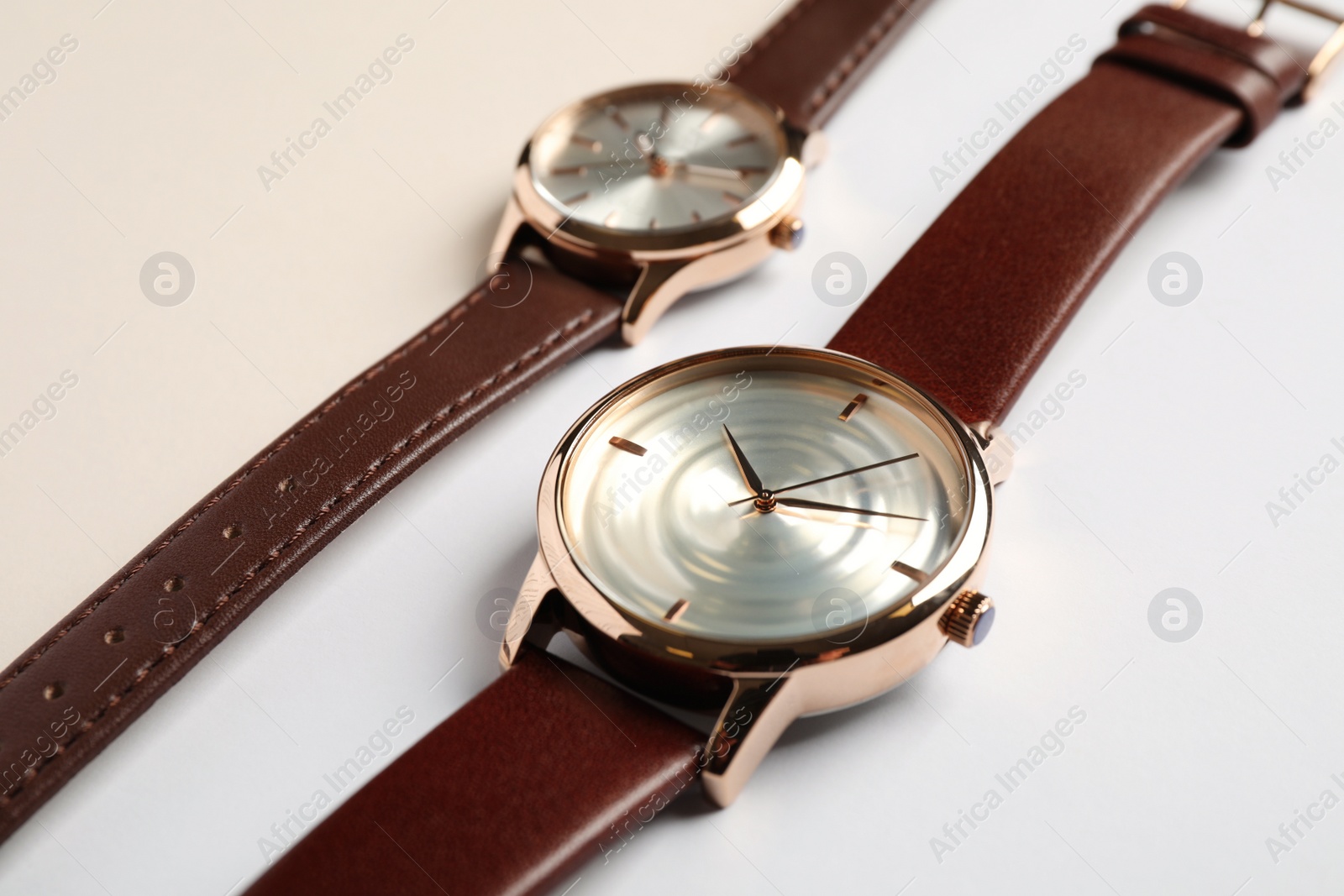 Photo of Luxury wrist watches on color background, closeup