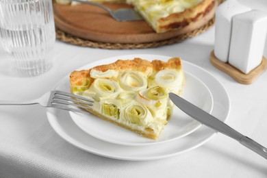 Photo of Piece of tasty leek pie served on table, closeup