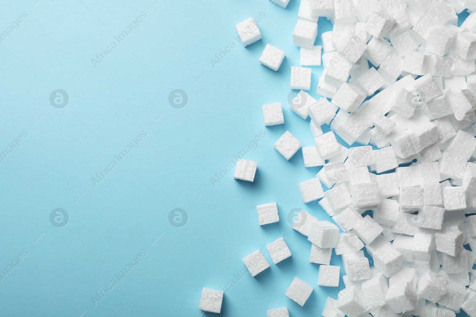 Photo of Many styrofoam cubes on light blue background, flat lay. Space for text