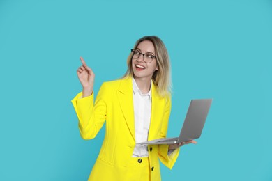 Photo of Young woman with modern laptop on light blue background