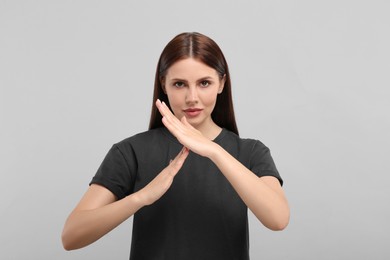 Photo of Woman showing time out gesture on grey background