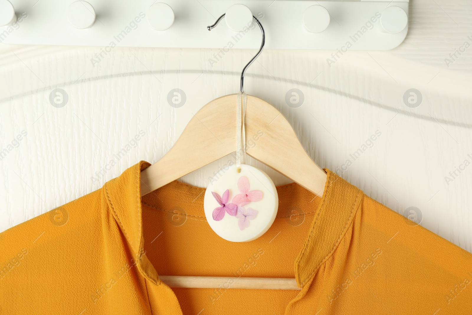 Photo of Scented sachet with flowers and stylish clothes on hanger