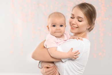 Portrait of happy mother with her baby against blurred lights