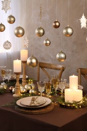 Photo of Christmas table setting with burning candles and festive decor