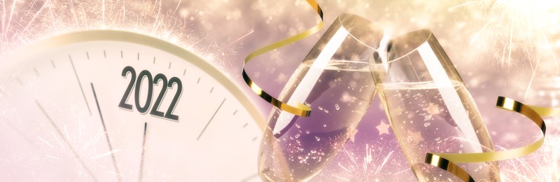 Glasses of sparkling wine, clock, shiny streamers and firework on color background, banner design. Countdown to New Year 2022