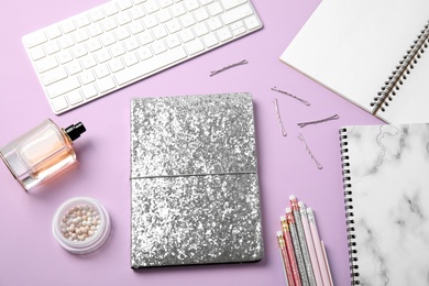 Blogger's workplace with notebook and keyboard on color background, flat lay