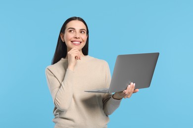 Photo of Happy woman with laptop on light blue background