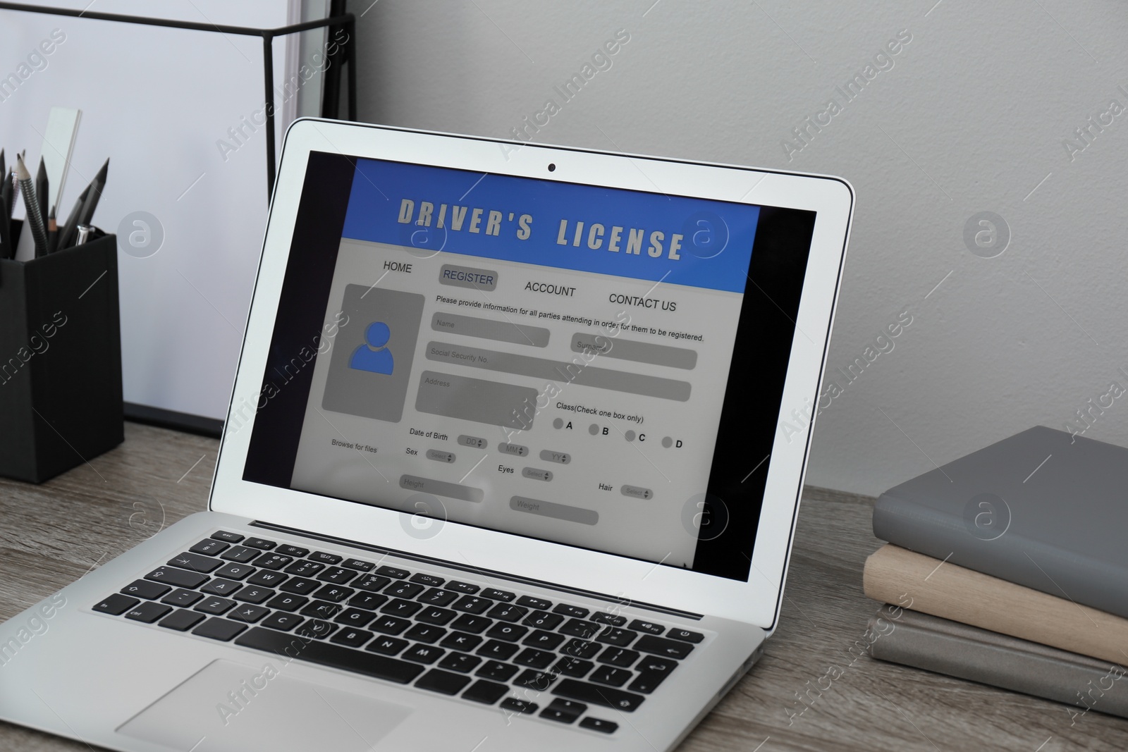 Photo of Laptop with driver's license application form on table in office