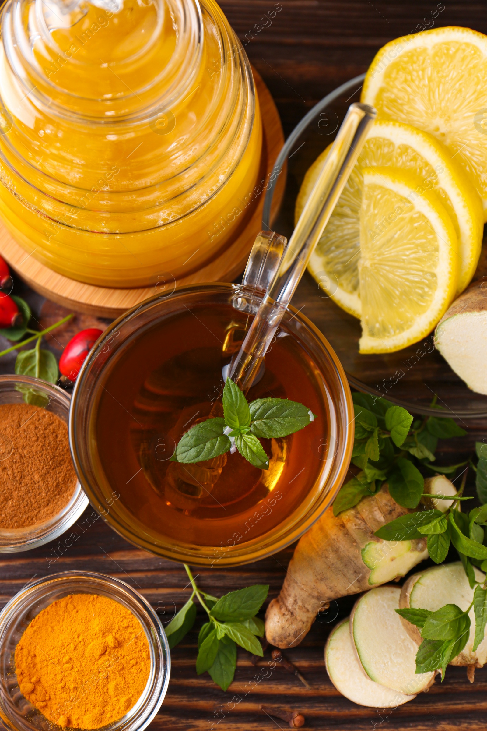 Photo of Flat lay composition of tea with honey and ingredients on wooden table