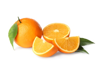 Photo of Cut and whole fresh ripe oranges with green leaves on white background