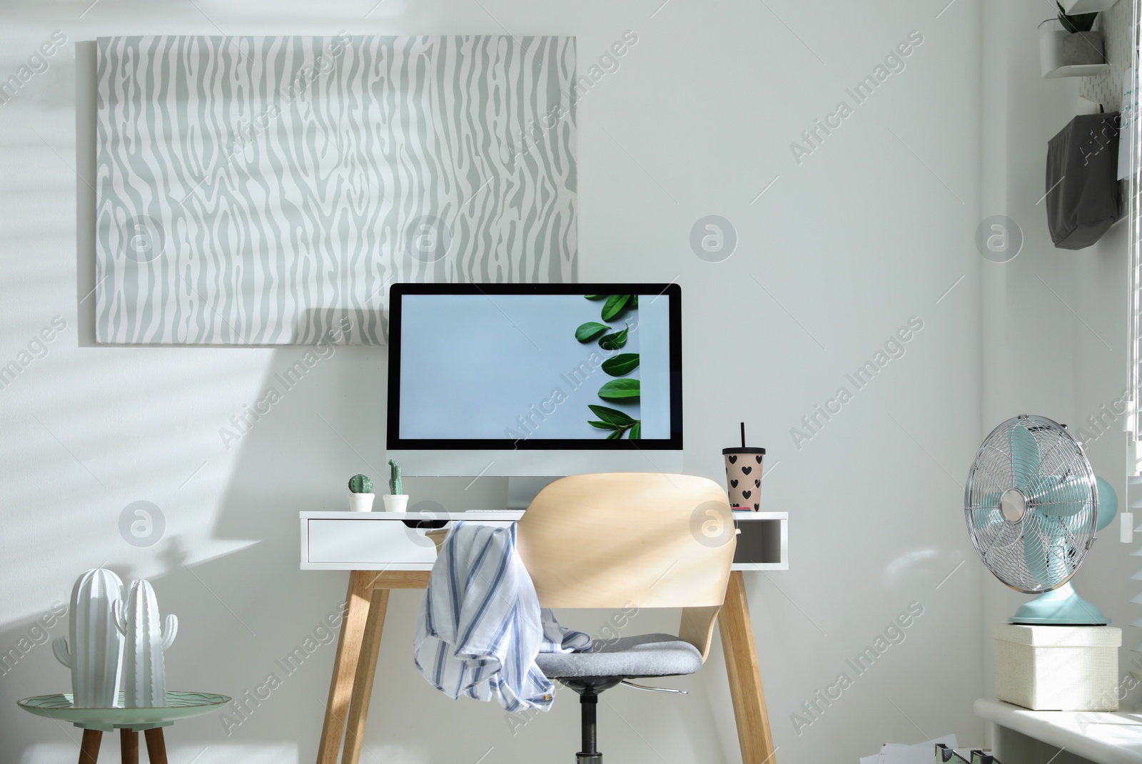 Photo of Comfortable office chair near desk with modern computer indoors