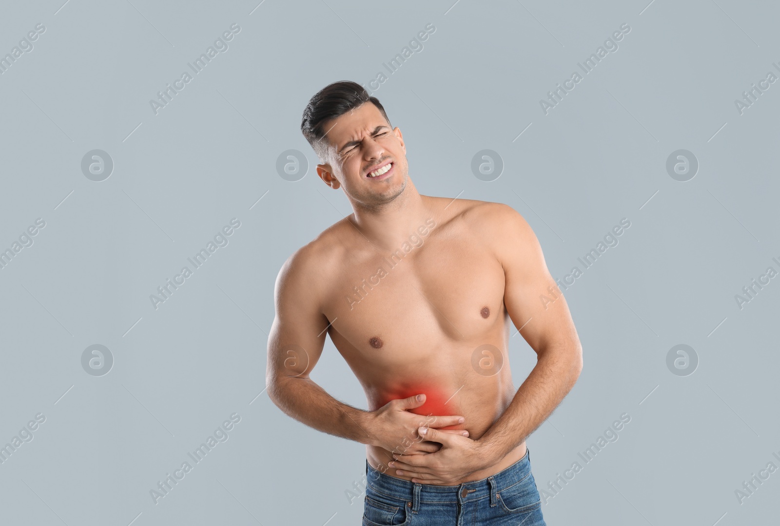 Photo of Man suffering from liver pain on grey background