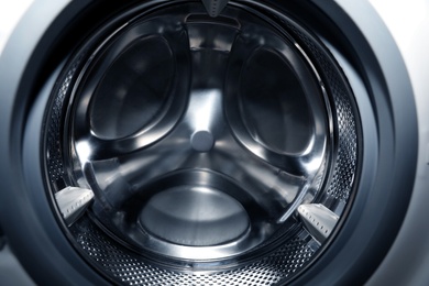 Photo of Empty washing machine drum, closeup. Laundry day