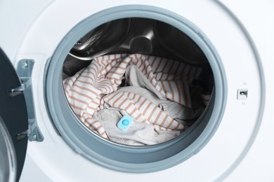 Photo of Water softener tablet on clothes in washing machine