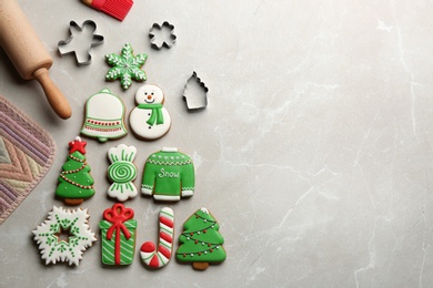 Kitchen utensils near Christmas tree shape made of delicious gingerbread cookies on marble table, flat lay. Space for text