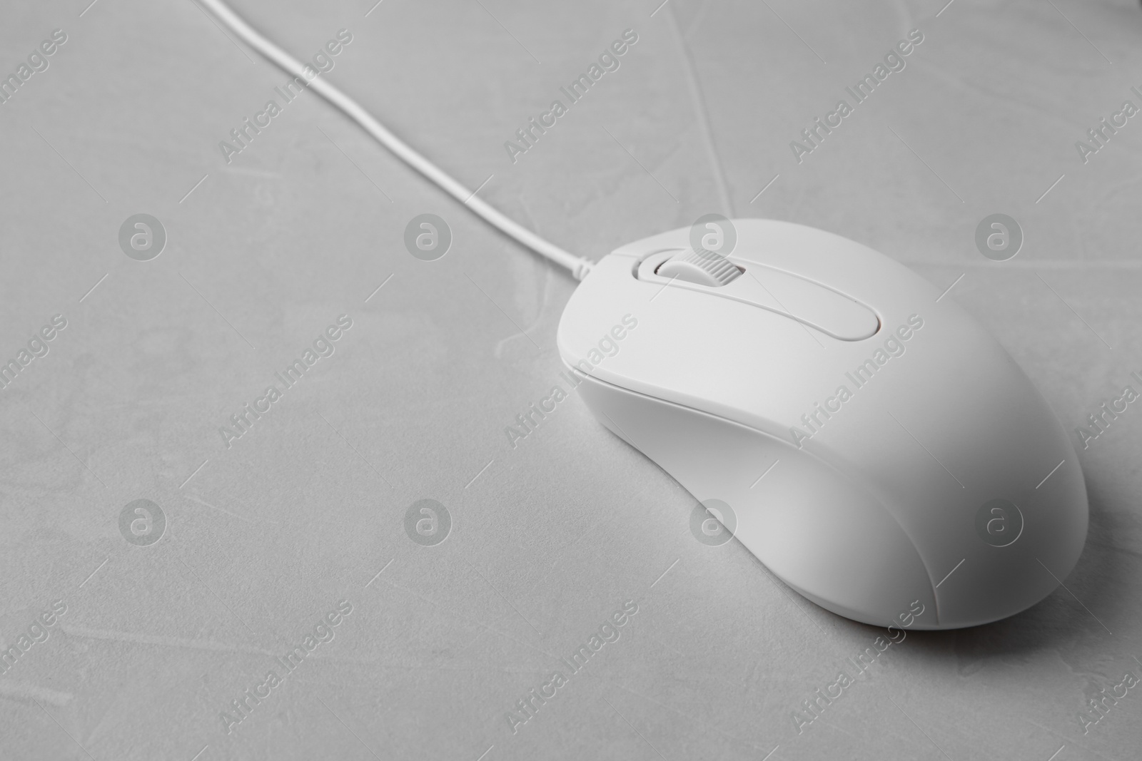 Photo of One wired mouse on grey textured table, closeup