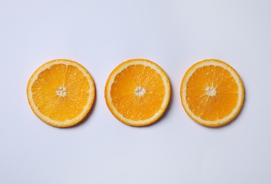 Photo of Fresh orange slices on light background, flat lay
