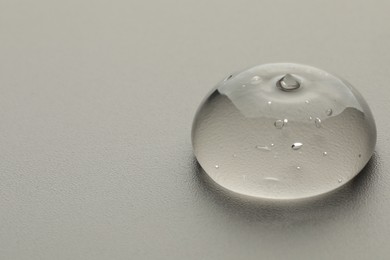 Photo of Sample of clear cosmetic gel on light grey background, closeup. Space for text