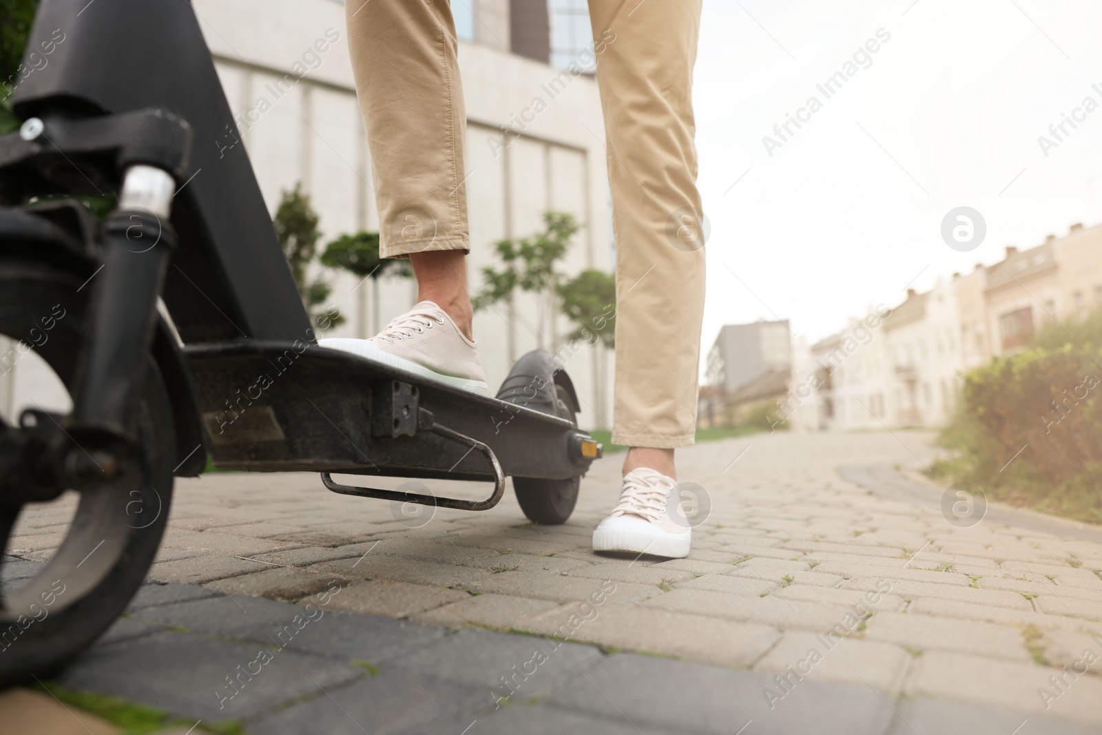 Photo of Man with modern kick scooter on city street, closeup. Space for text