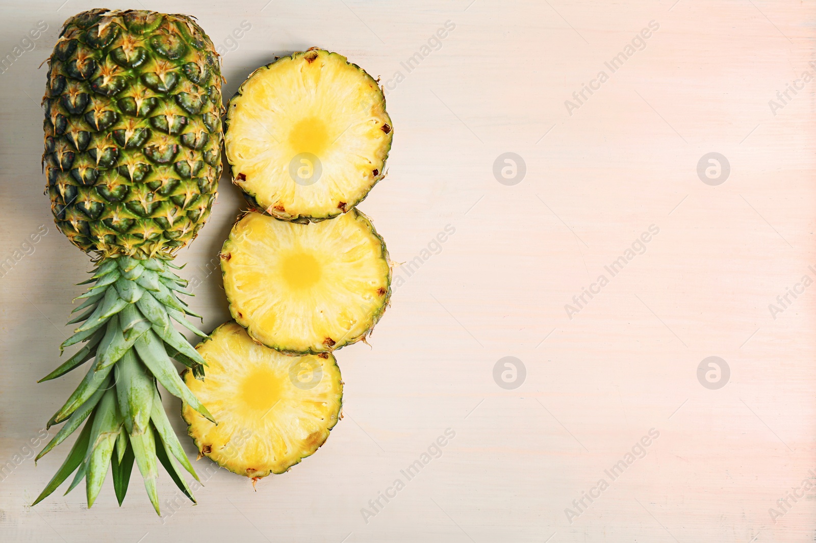 Photo of Fresh pineapples on wooden background, flat lay