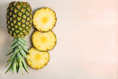 Photo of Fresh pineapples on wooden background, flat lay