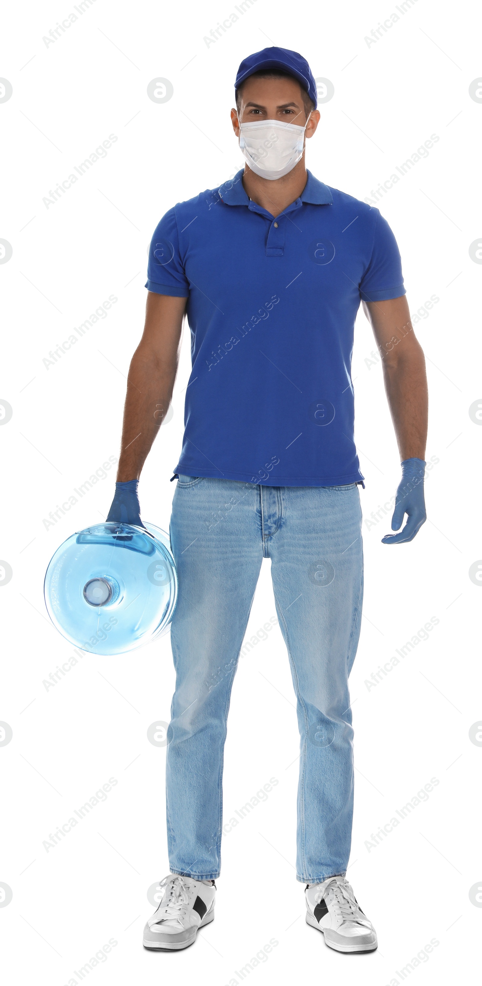 Photo of Courier in medical mask holding bottle for water cooler on white background. Delivery during coronavirus quarantine