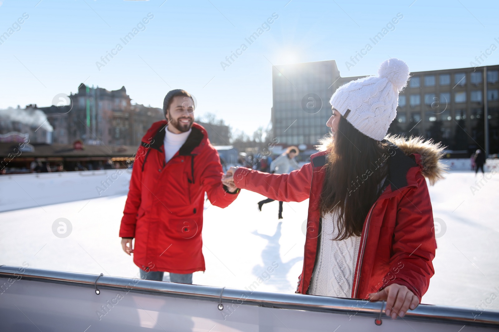 Image of Lovely couple spending time together at outdoor ice skating rink