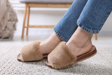 Photo of Woman in brown soft slippers at home, closeup