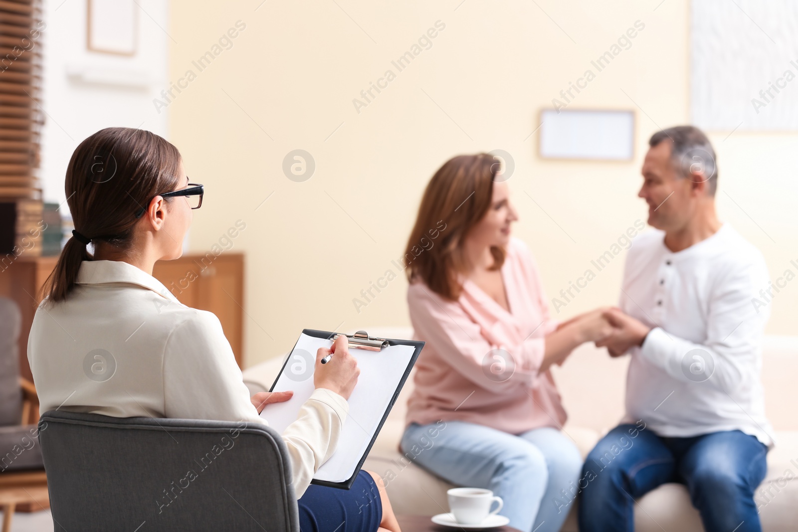 Photo of Psychotherapist and happy couple having meeting in office. Family counselling