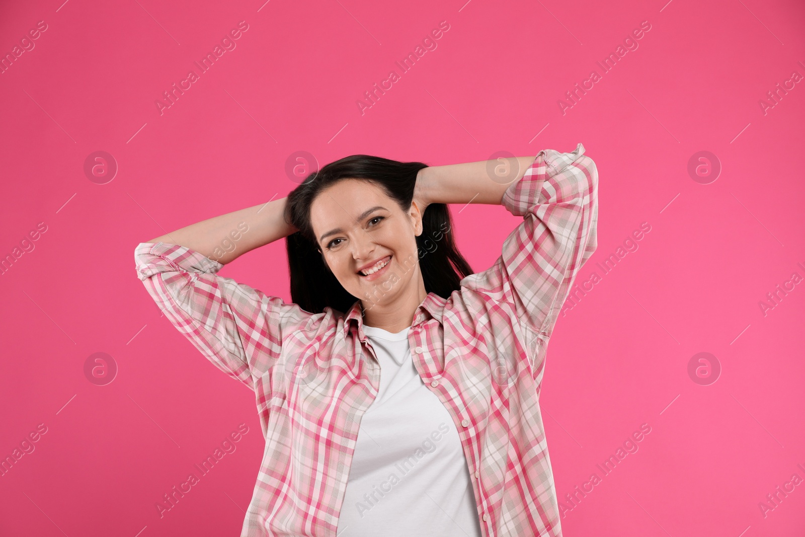 Photo of Beautiful overweight woman with charming smile on pink background