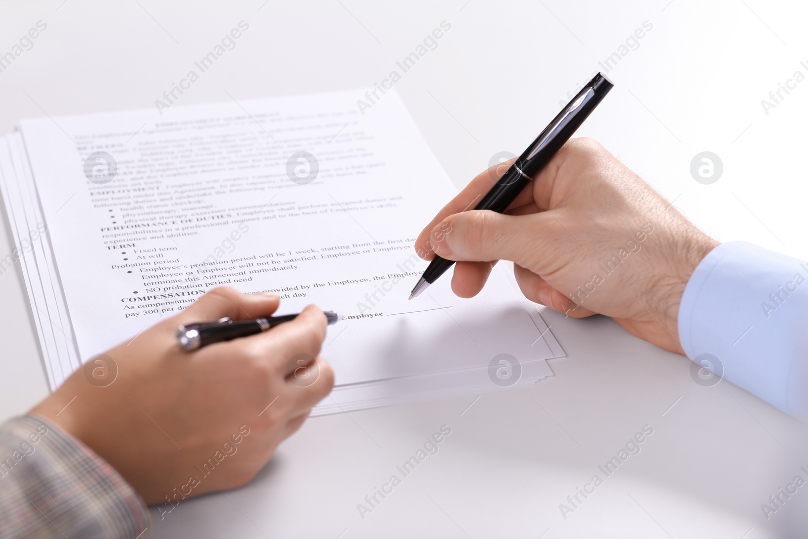 Photo of Businesspeople signing contract at white table, closeup of hands