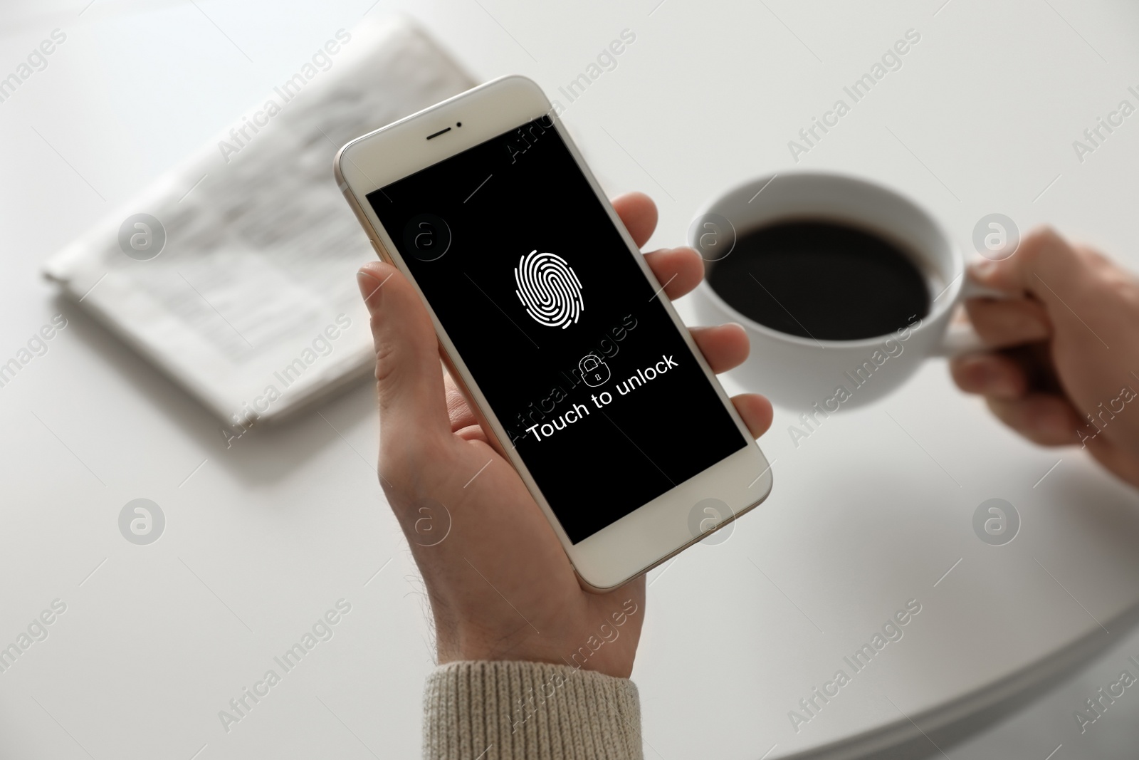 Image of Man holding smartphone with fingerprint sensor indoors, closeup. Digital identity