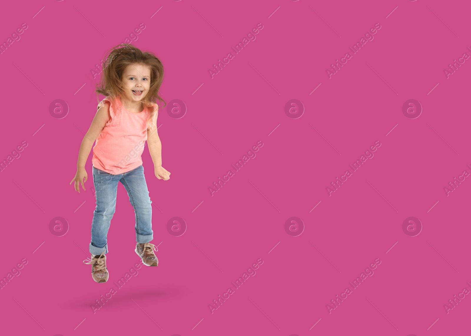 Image of Cute girl jumping on dark pink background, space for text