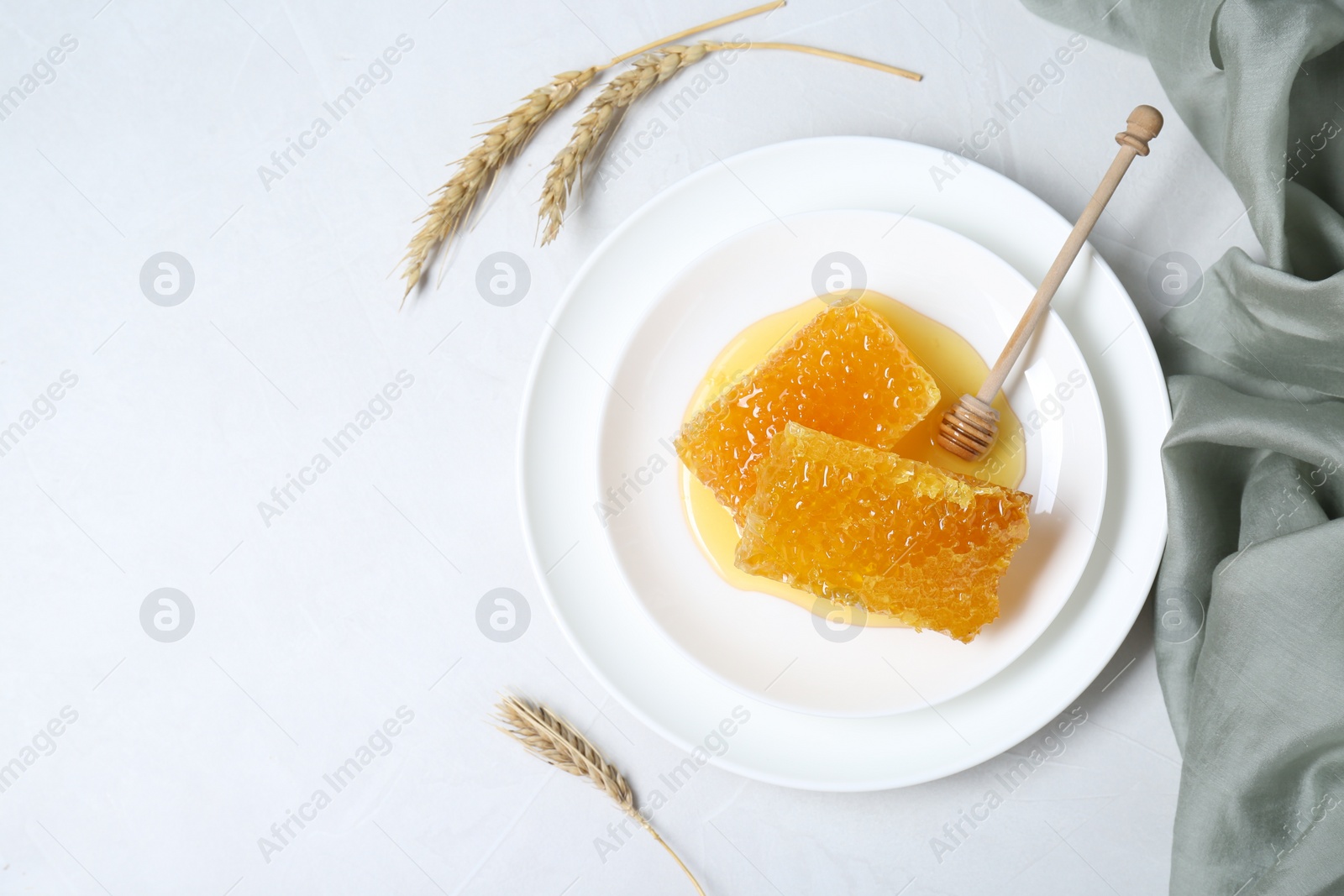 Photo of Natural honeycombs with tasty honey and dipper on white table, flat lay. Space for text