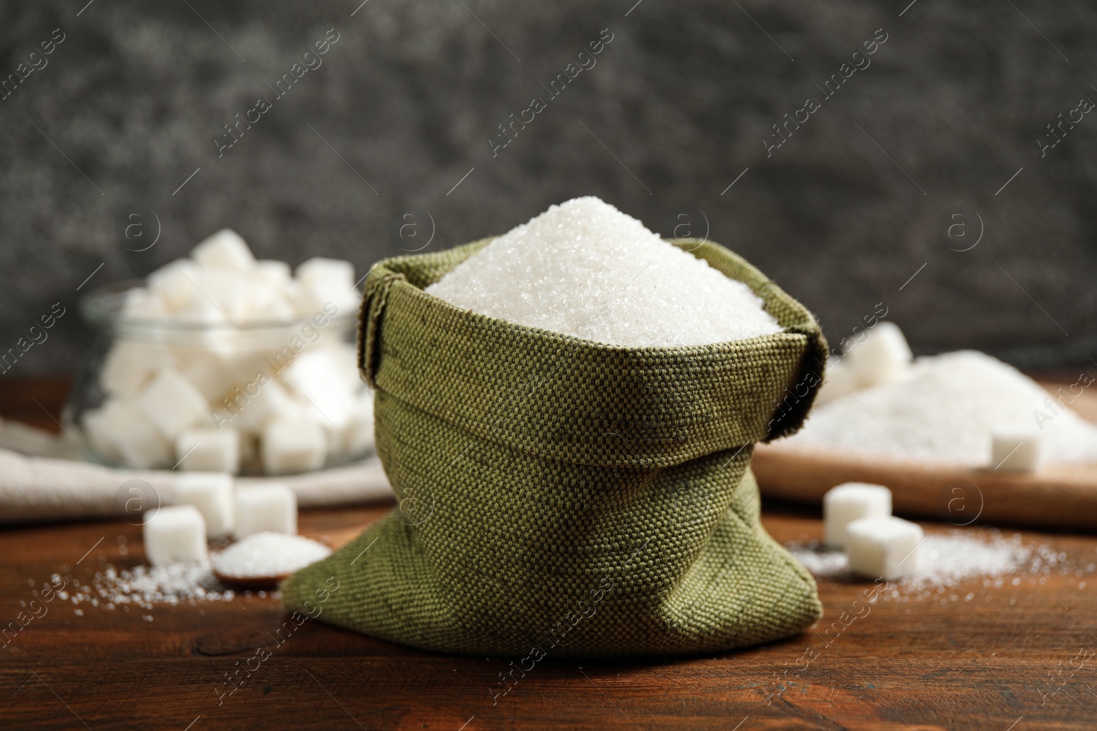 Photo of Granulated sugar in sack on wooden table