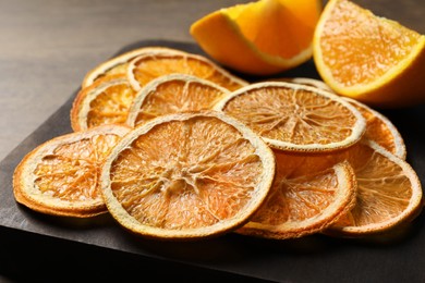 Photo of Dry orange slices on wooden board, closeup