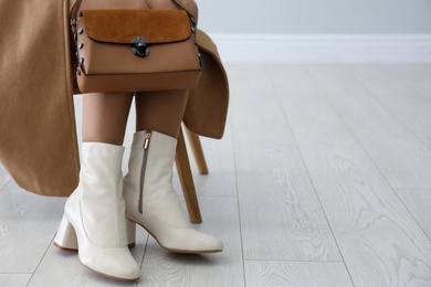 Photo of Woman in stylish leather shoes with bag indoors, closeup. Space for text