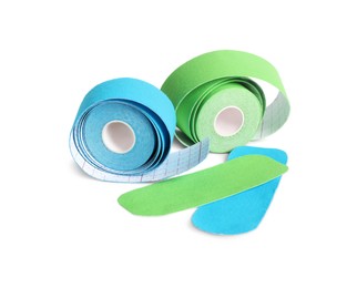Photo of Bright kinesio tape rolls and pieces on white background, space for text
