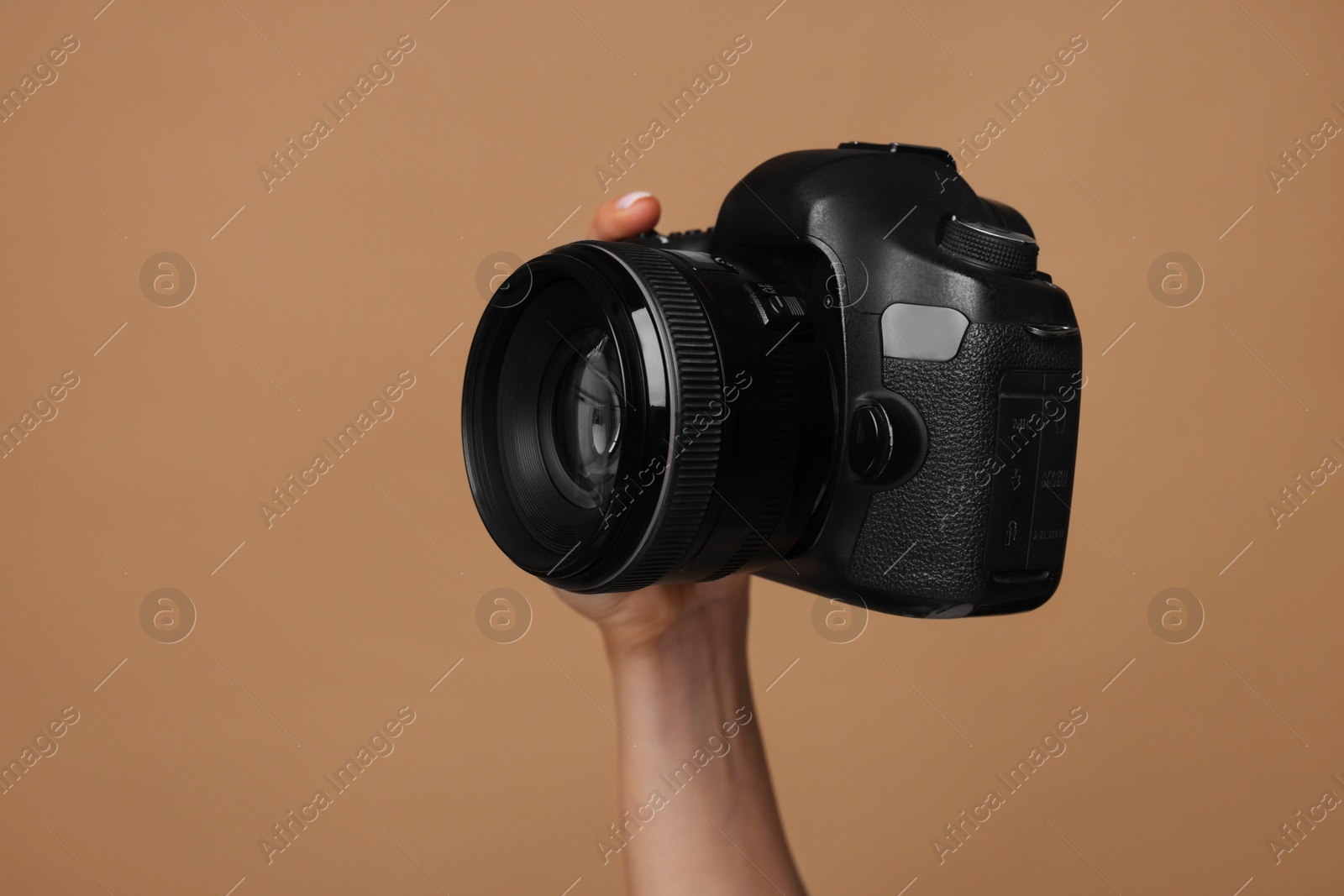 Photo of Photographer with camera on brown background, closeup. Space for text