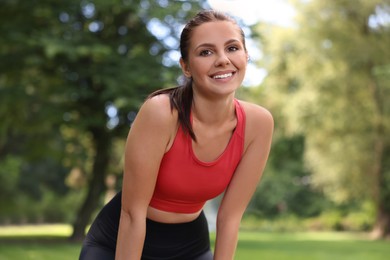 Photo of Portrait of smiling woman wearing sportswear in park