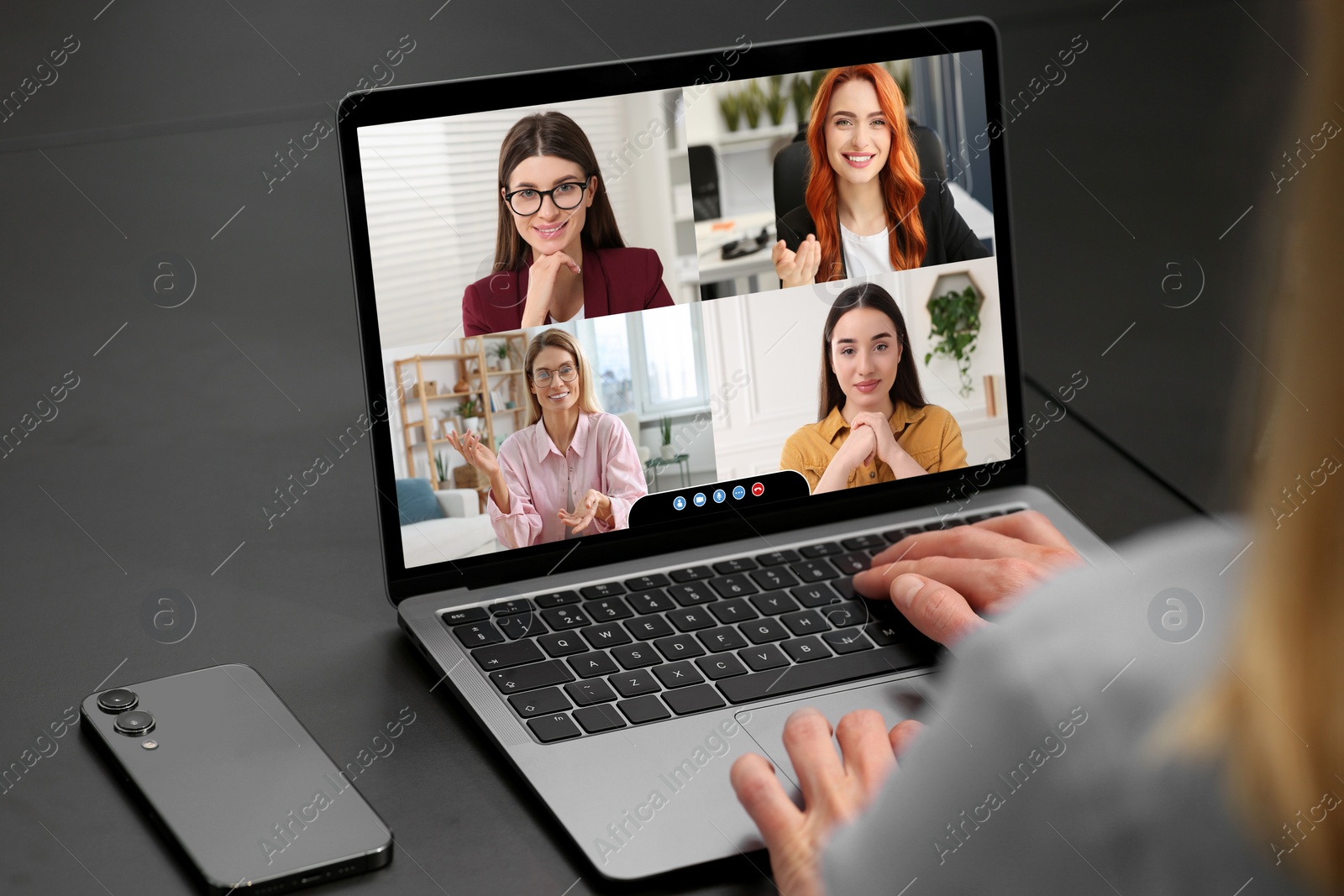Image of Woman having video chat with coworkers via laptop at black table, closeup