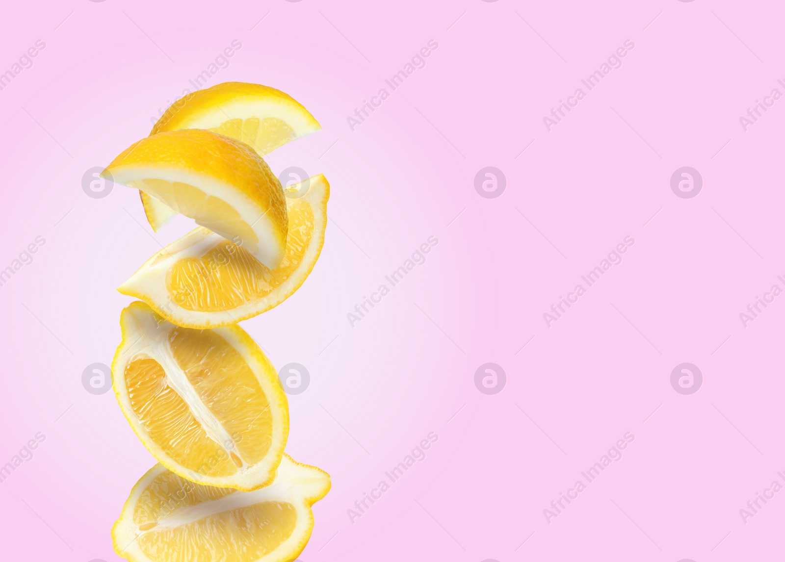 Image of Cut fresh ripe lemons falling on pink background, space for text
