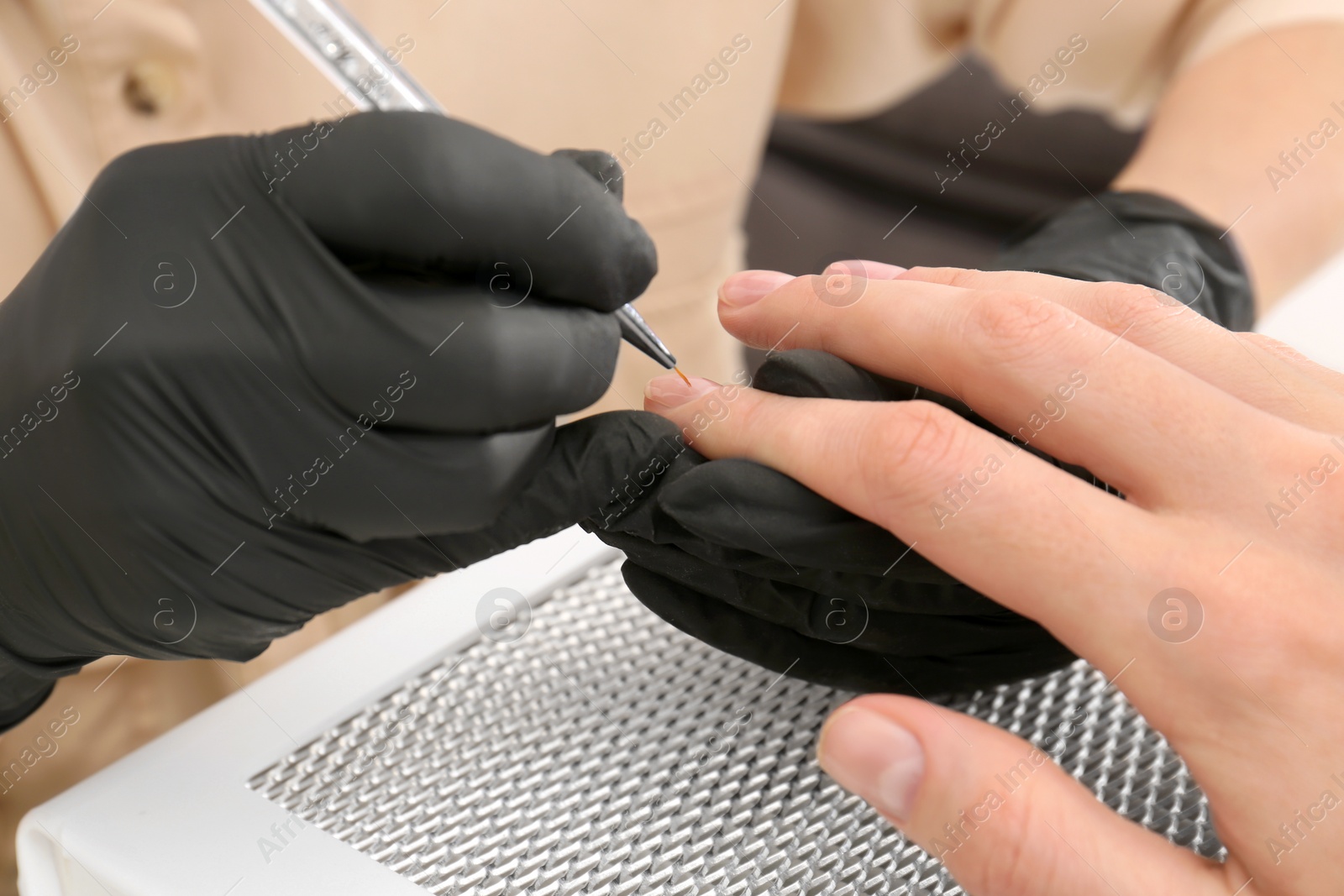 Photo of Professional manicurist working with client, closeup view