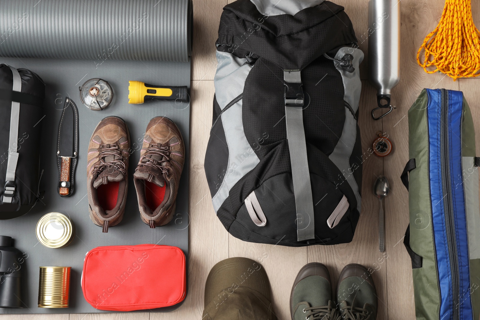 Photo of Flat lay composition with different camping equipment on wooden background